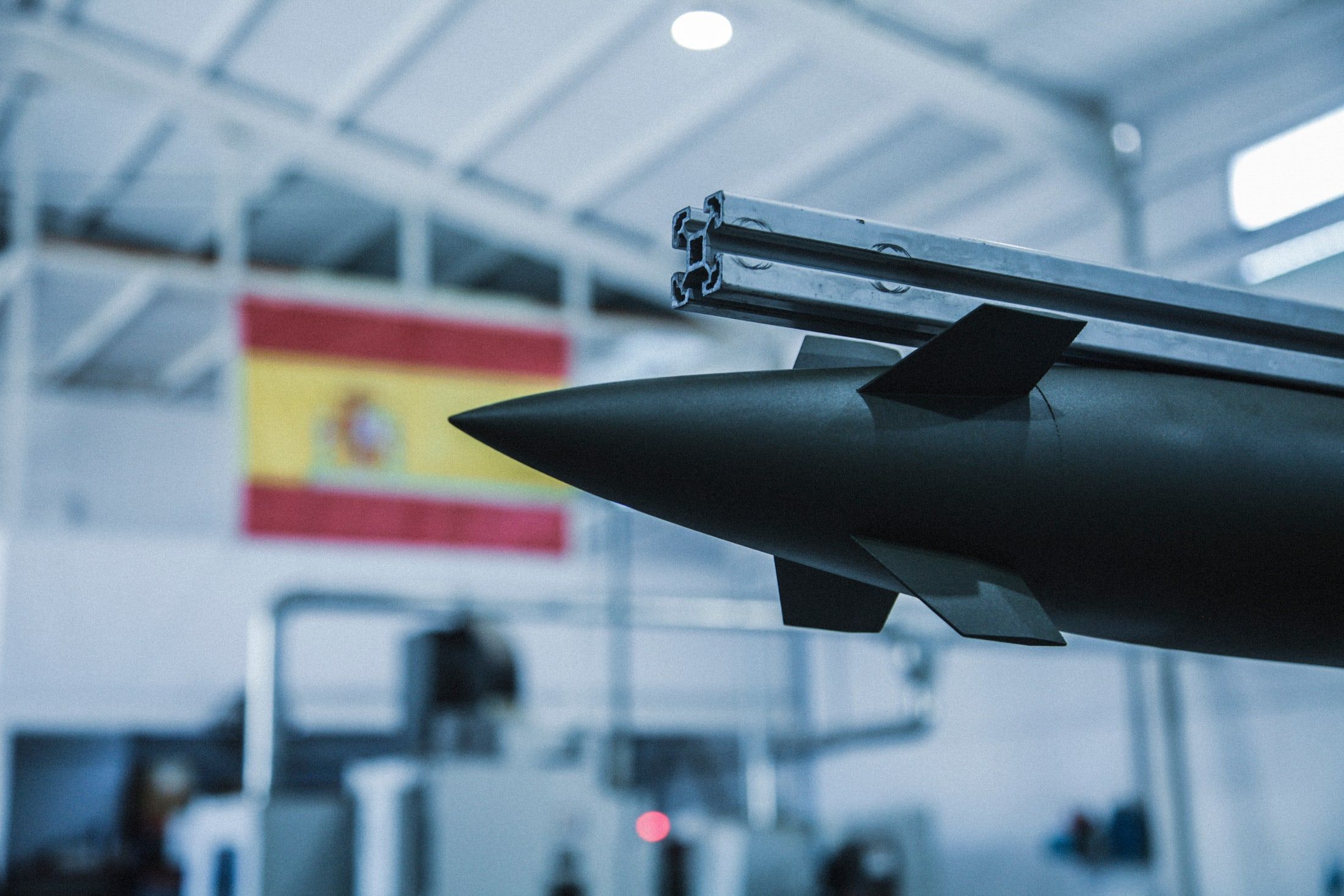 Ojiva de un motor cohete junto a una bandera de España en el taller de Nerva Technologies.